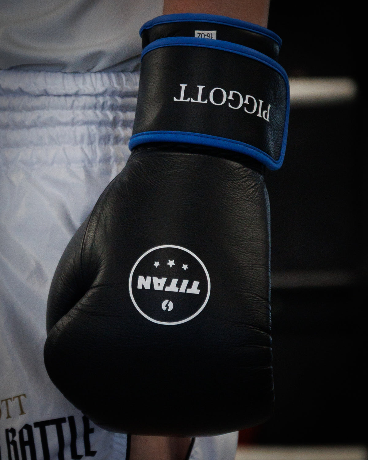 Titan Bespoke Velocity 3.0 velcro boxing glove in custom black leather with royal blue trim and personalised PIGGOTT name