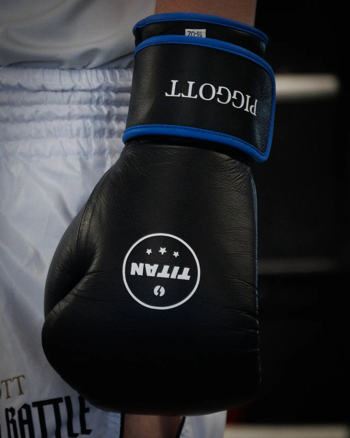 Personalised black boxing glove with royal blue trim and the name PIGGOTT embroidered on the cuff
