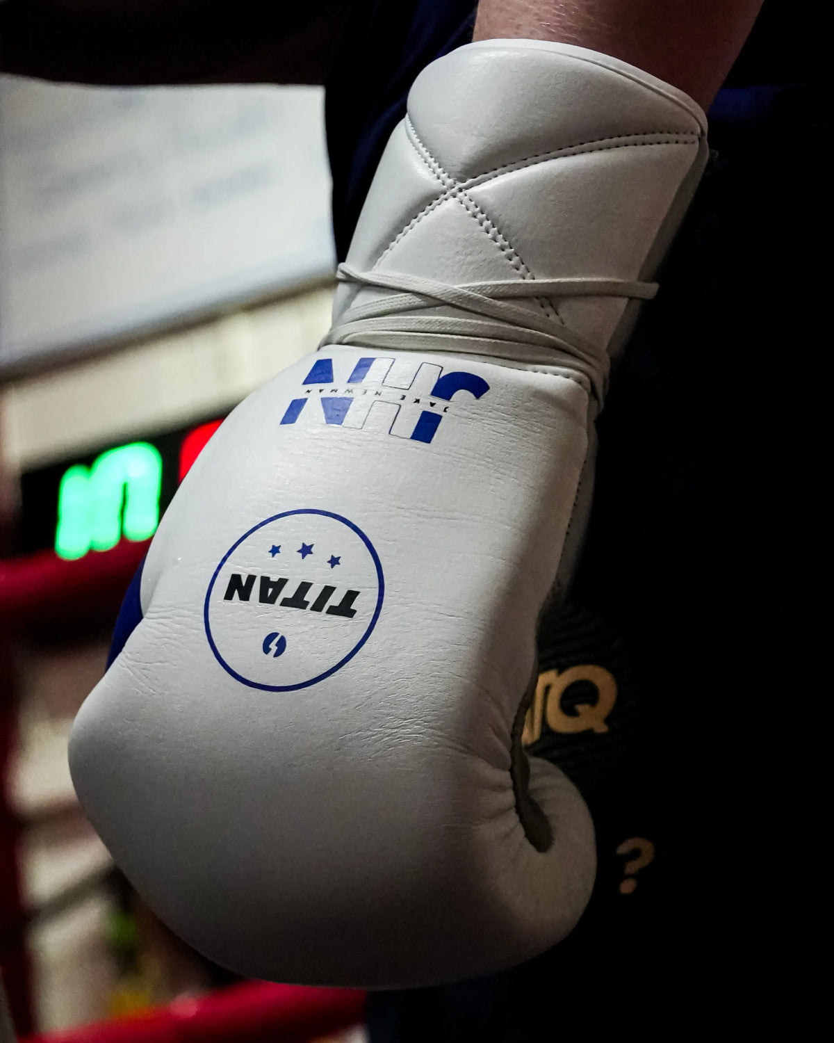 Custom white lace-up boxing glove with navy JHN logo and blue Titan roundel