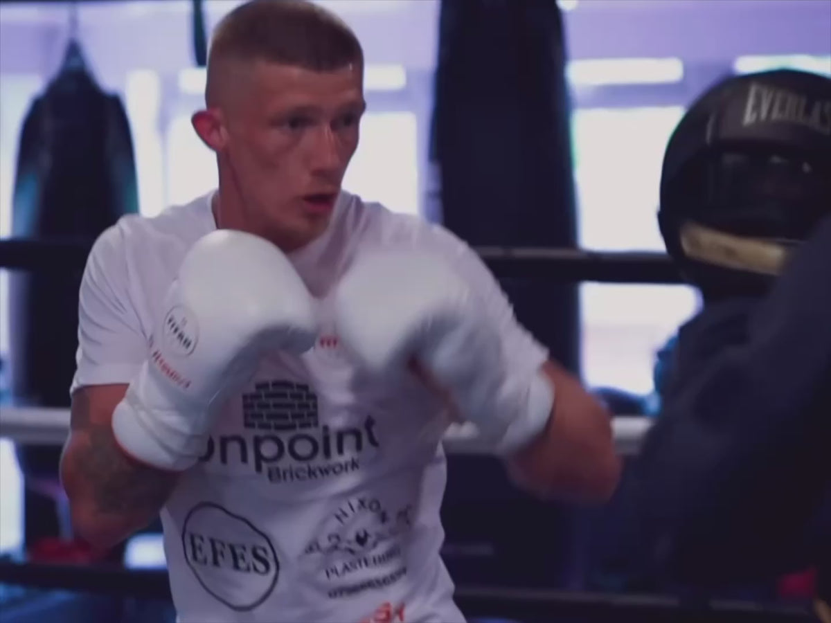 Load video: Boxer in white Titan boxing gloves training in a ring